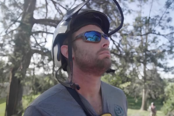 Close-up of Ostvig arborist wearing climbing helmet in Wayzata service area.