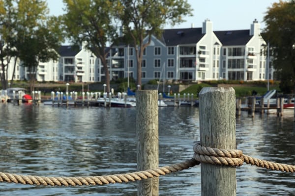Dock with boats on Excelsior Bay, waterfront homes and trees in background.