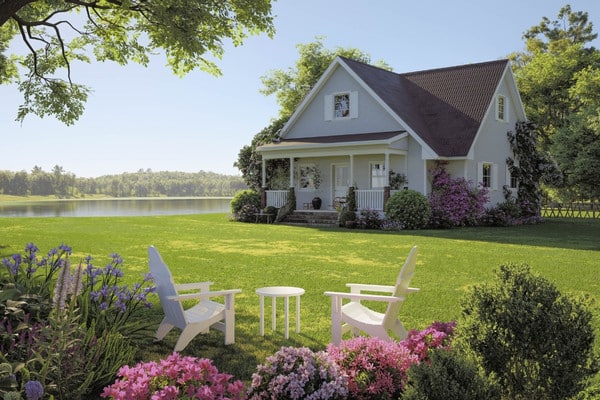 Mature trees framing scenic residential home with lake view and manicured landscape.
